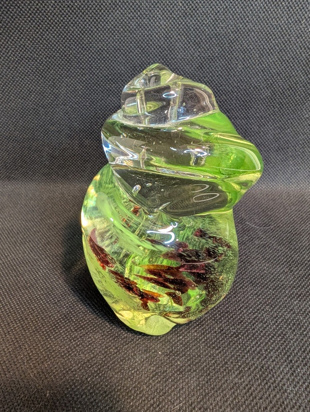A vintage paperweight made of green and Red swirls in the glass.